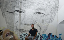 Künstler boxt Mandela-Portrait an Wand